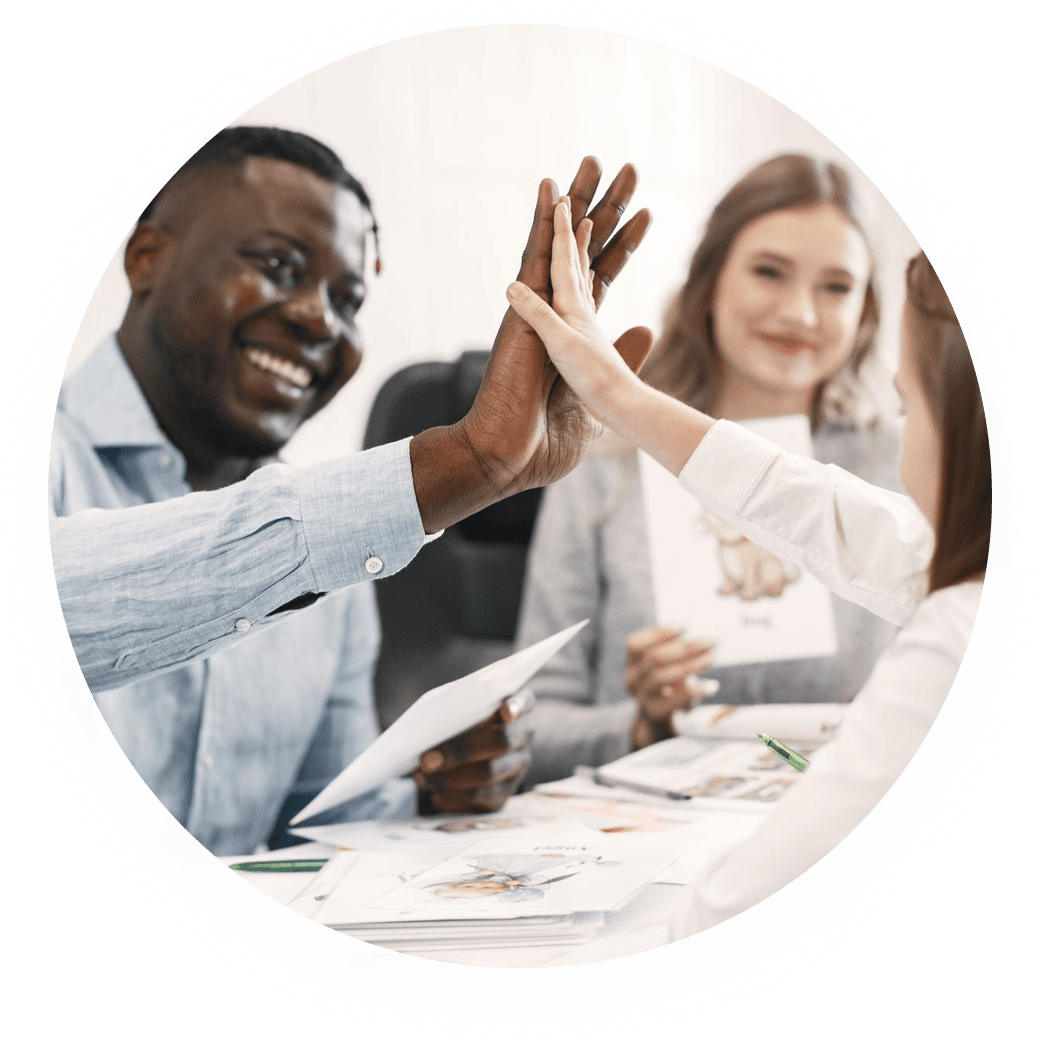 Tutor high-fiving learners at a desk